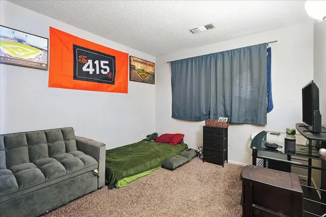 a living room with furniture a flat screen tv and a window