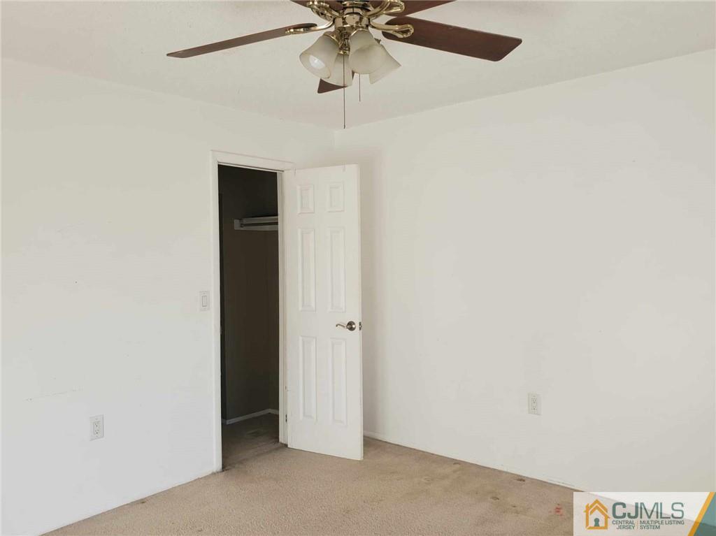 242 Azalea Circle Jackson, NJ 08527 - Photo 7 of 8 an empty room with a ceiling fan and a window