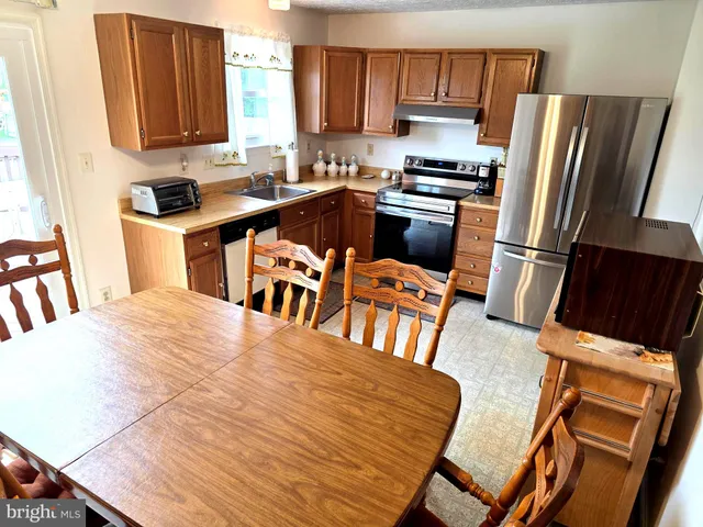 a kitchen with stainless steel appliances a stove a sink dishwasher and a refrigerator