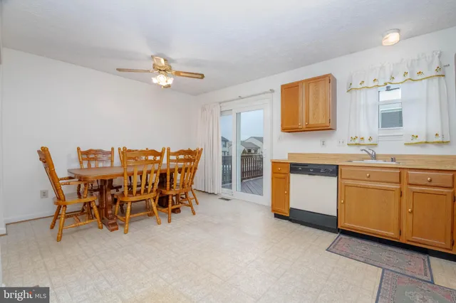 a view of a kitchen with a dining table chairs and entryway