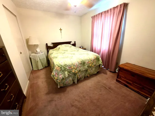 a spacious bedroom with a bed and wooden floor