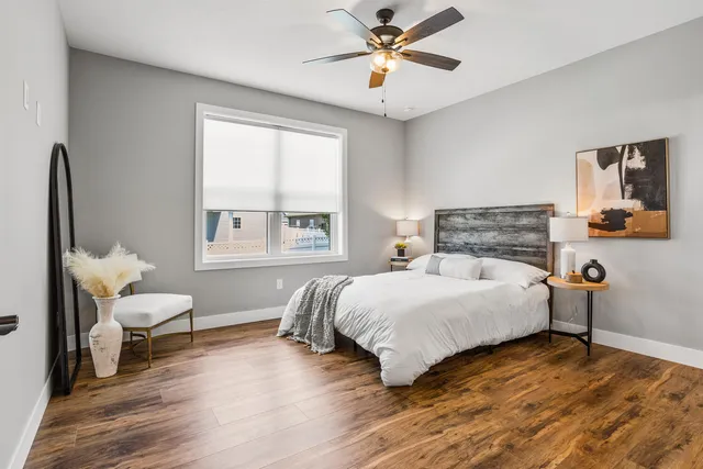 a bedroom with a bed wooden floor and window