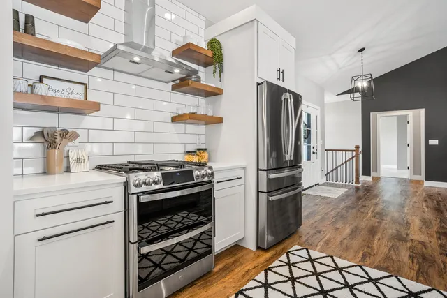 a kitchen with granite countertop a refrigerator and a stove top oven