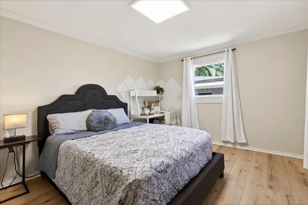 a bedroom with a large bed and wooden floor