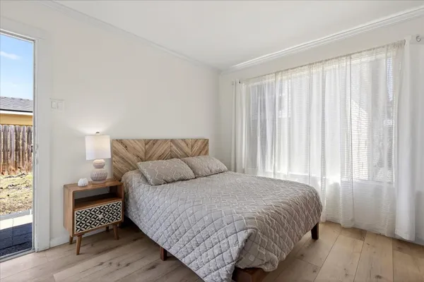 a bedroom with a bed and wooden floor
