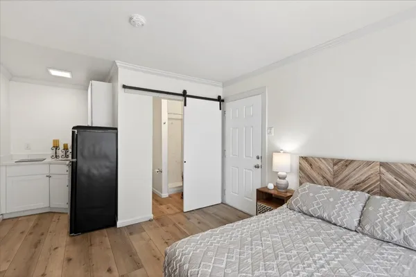a bedroom with a bed and wooden floor