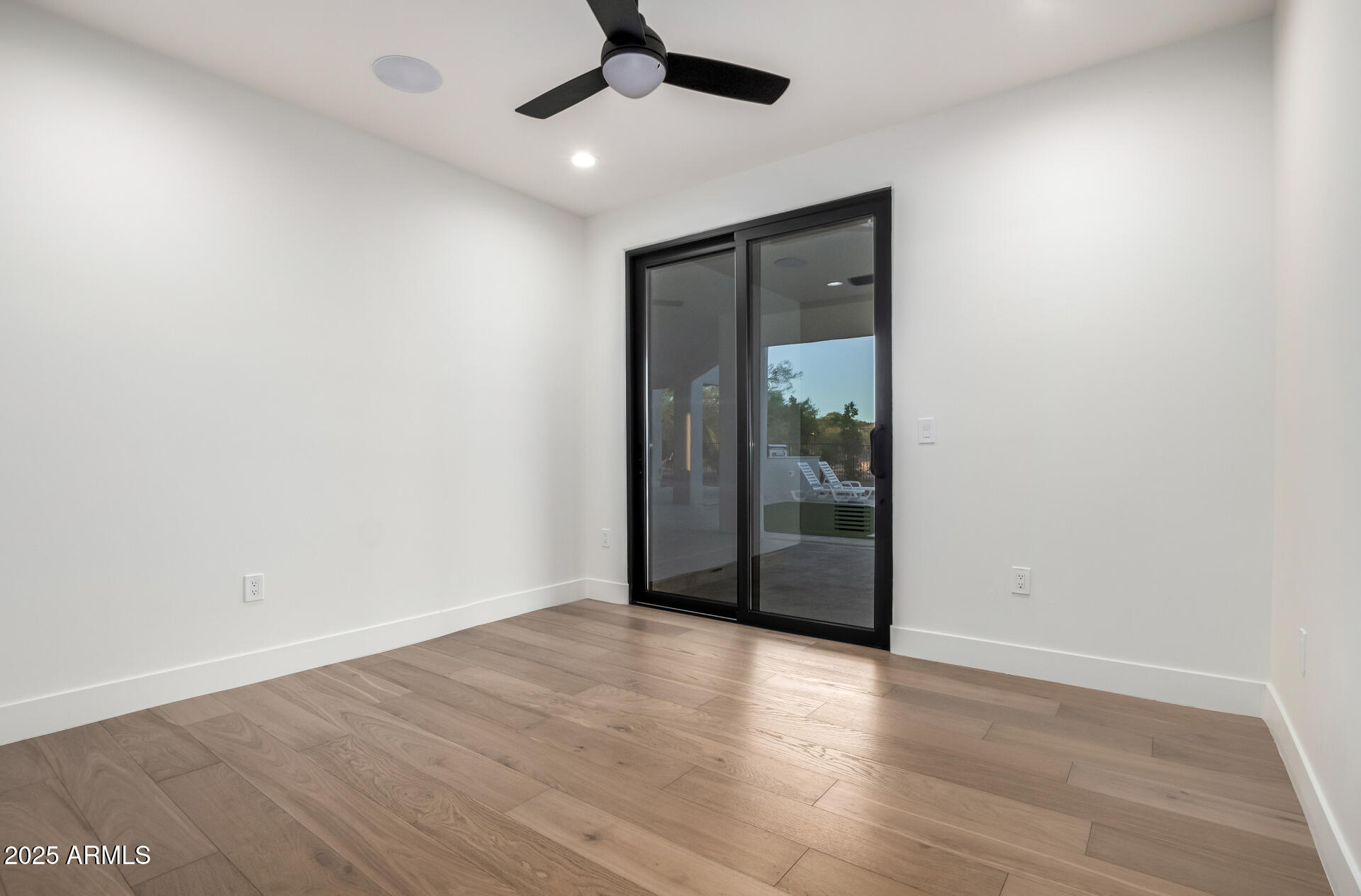 6735 East Dove Valley Road Cave Creek, AZ 85331 - Photo 31 of 58 an empty room with wooden floor fan and windows