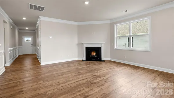 an empty room with wooden floor and a fireplace
