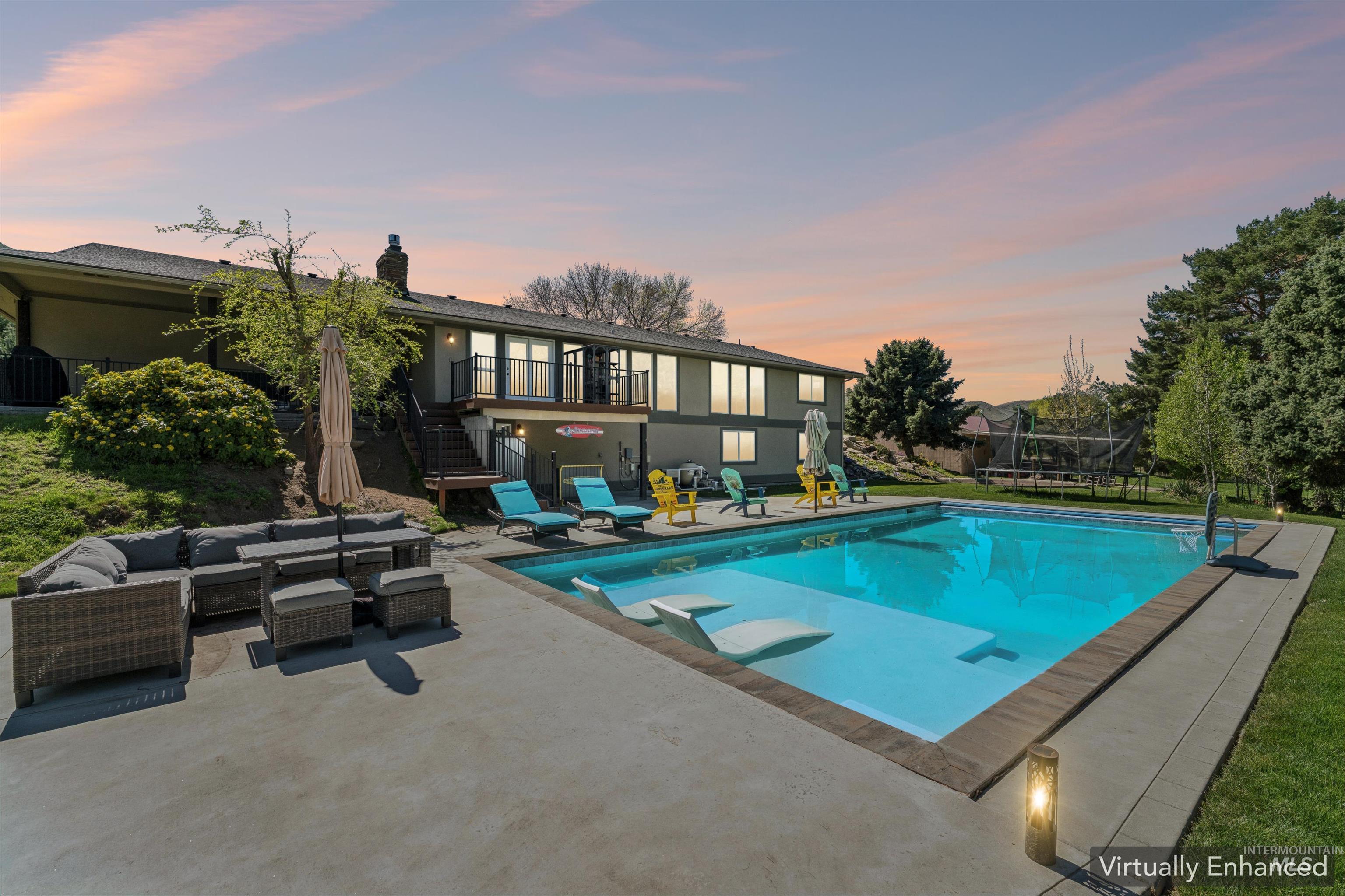 1050 West South Slope Road Emmett, ID 83617 - Photo 1 of 49 View of swimming pool with patio surround, outdoor seating, a balcony, and a trampoline