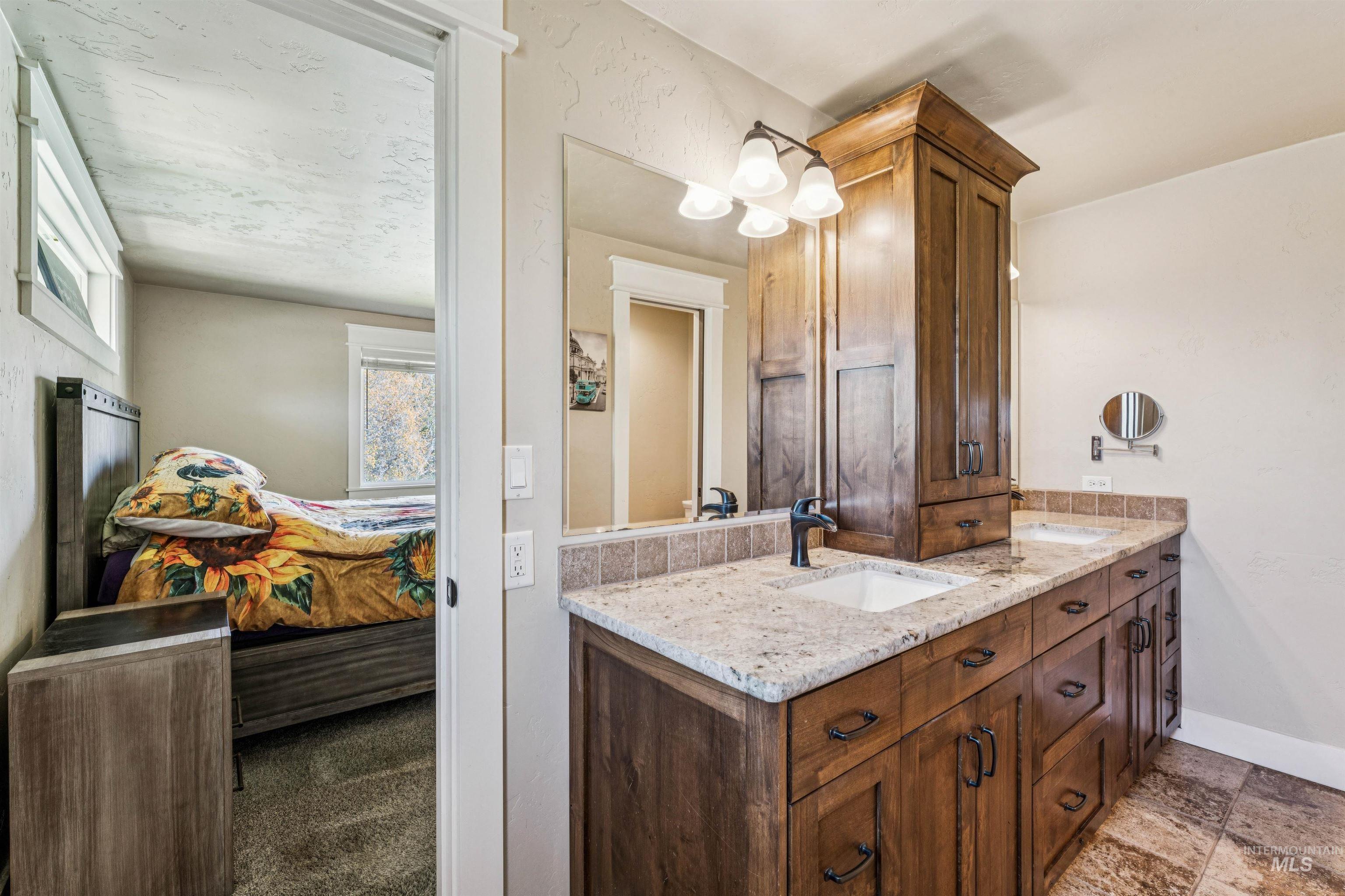 1050 West South Slope Road Emmett, ID 83617 - Photo 17 of 49 Full bath with double vanity, ensuite bath, and dark stone finish floors