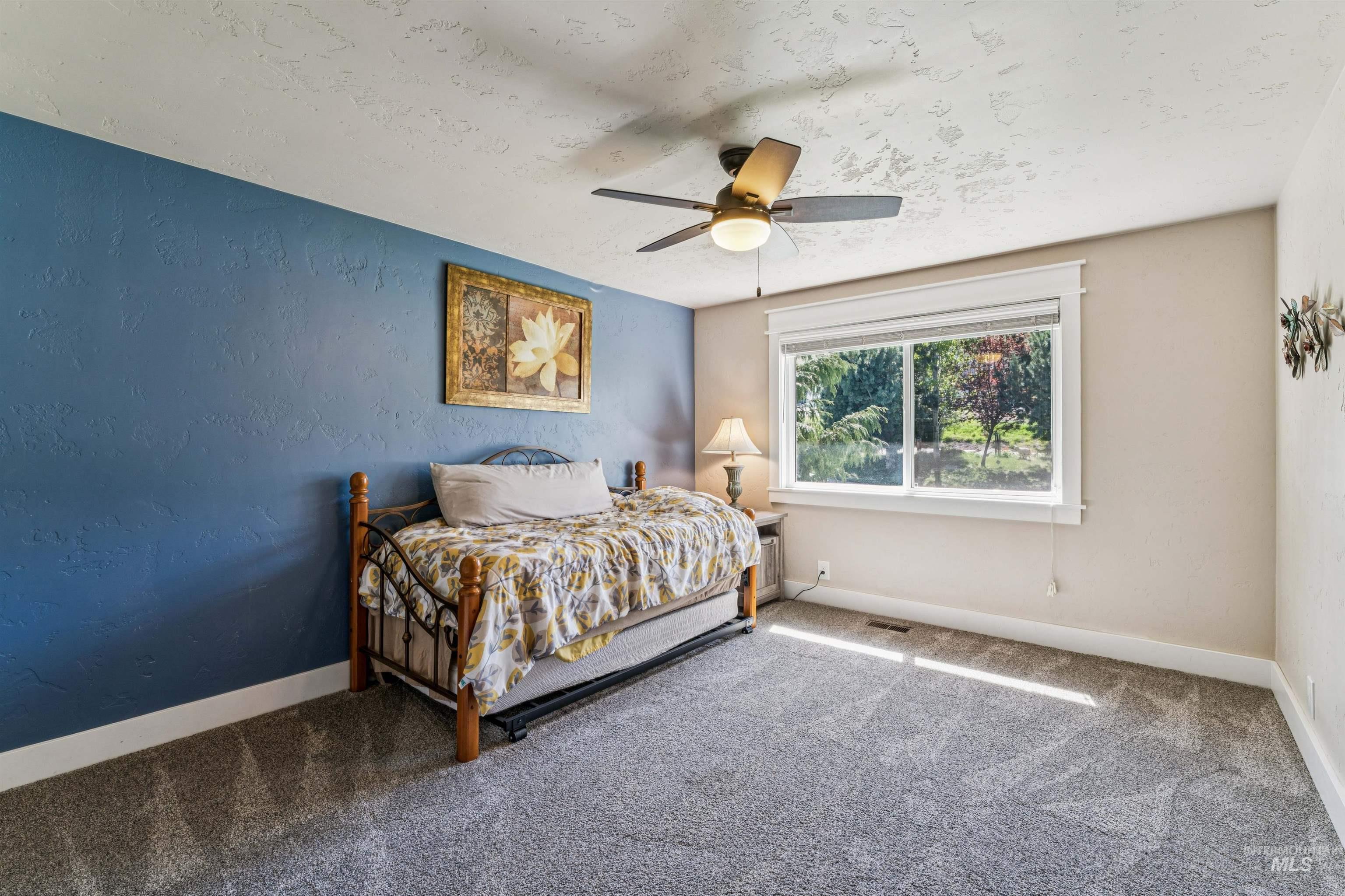 1050 West South Slope Road Emmett, ID 83617 - Photo 23 of 49 Carpeted bedroom featuring a textured wall, a textured ceiling, and ceiling fan