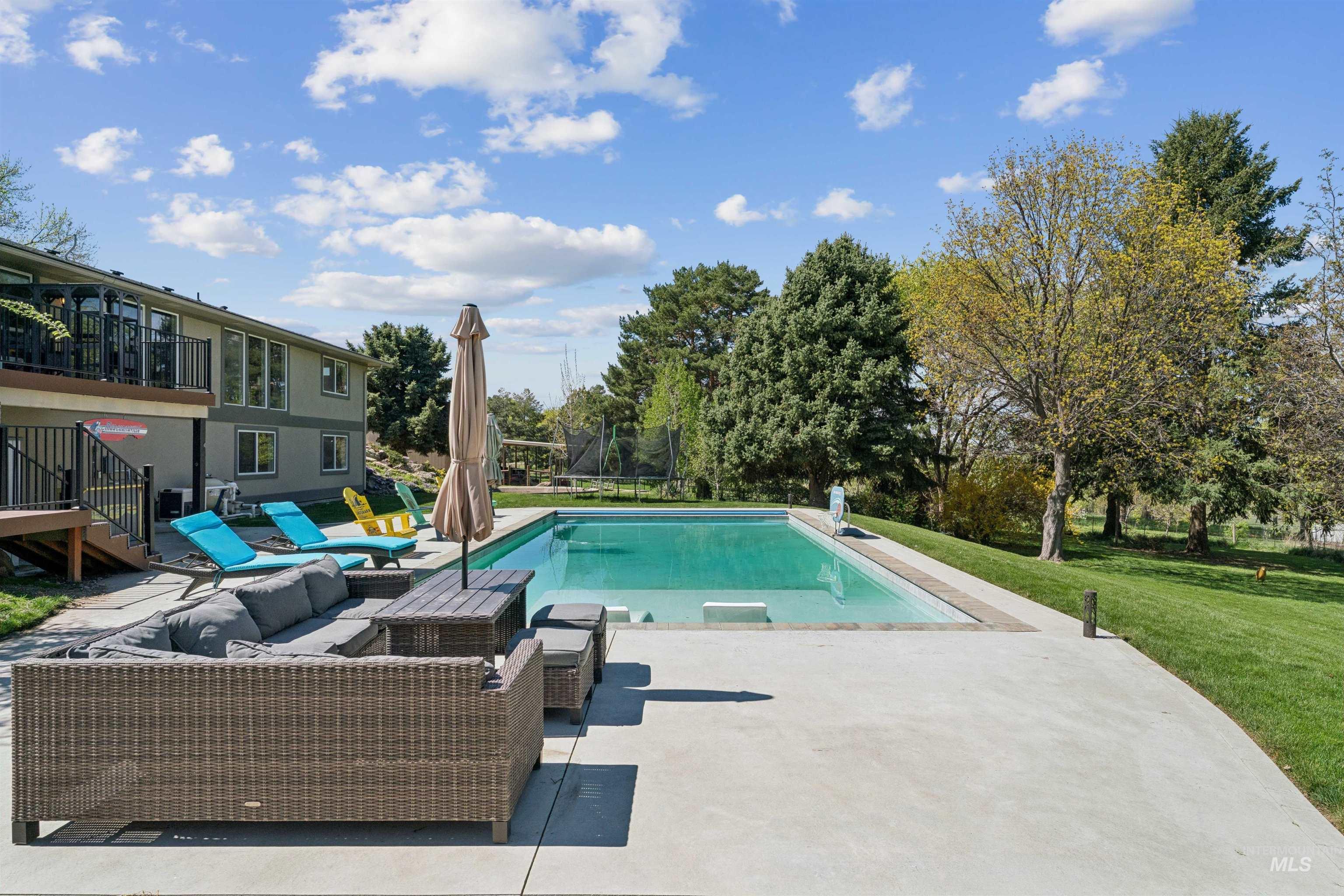 1050 West South Slope Road Emmett, ID 83617 - Photo 34 of 49 Outdoor pool with a patio, an outdoor lounge area, a yard, and a trampoline