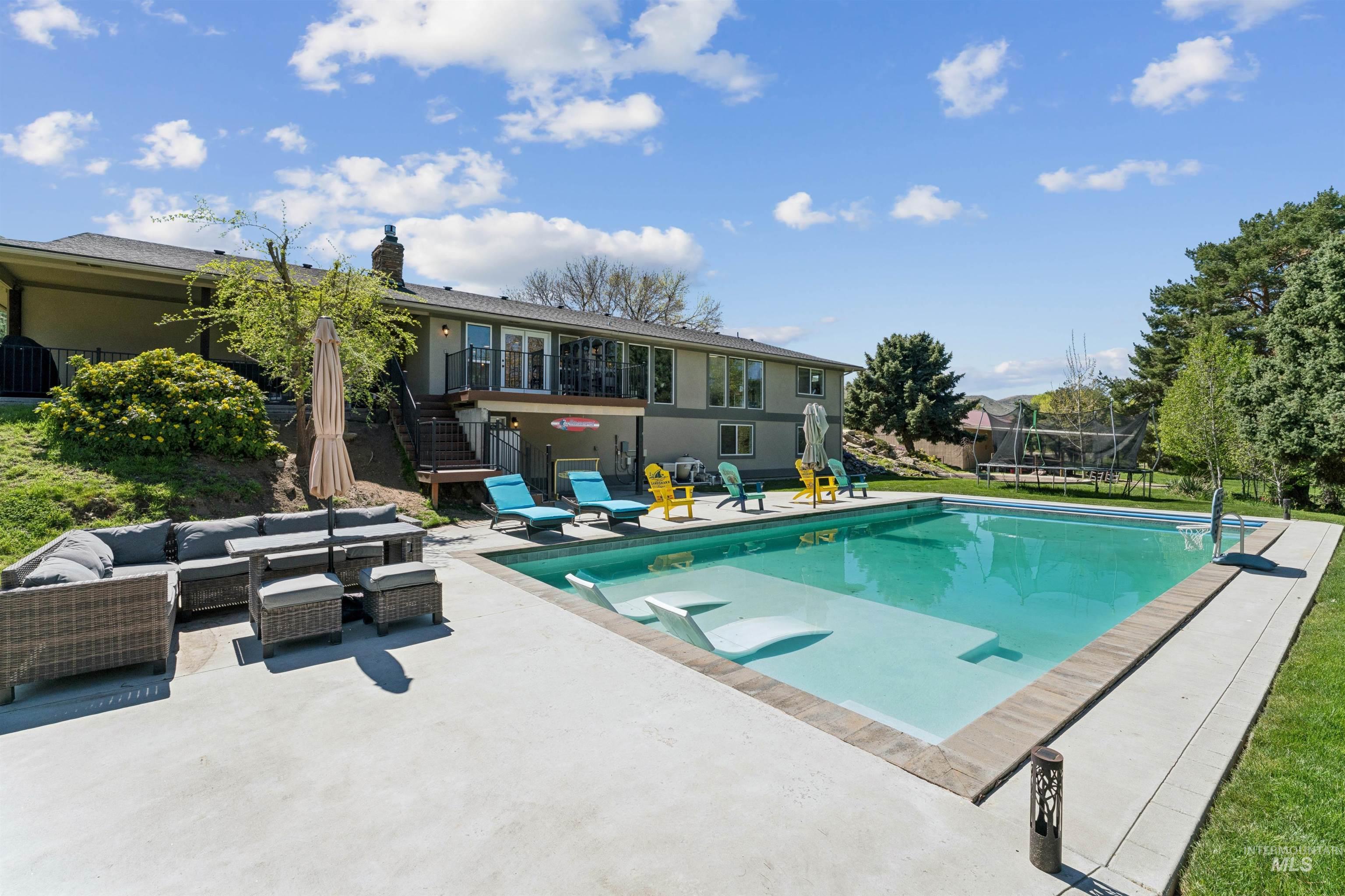1050 West South Slope Road Emmett, ID 83617 - Photo 35 of 49 View of swimming pool with patio surround, outdoor seating, a trampoline, and a balcony