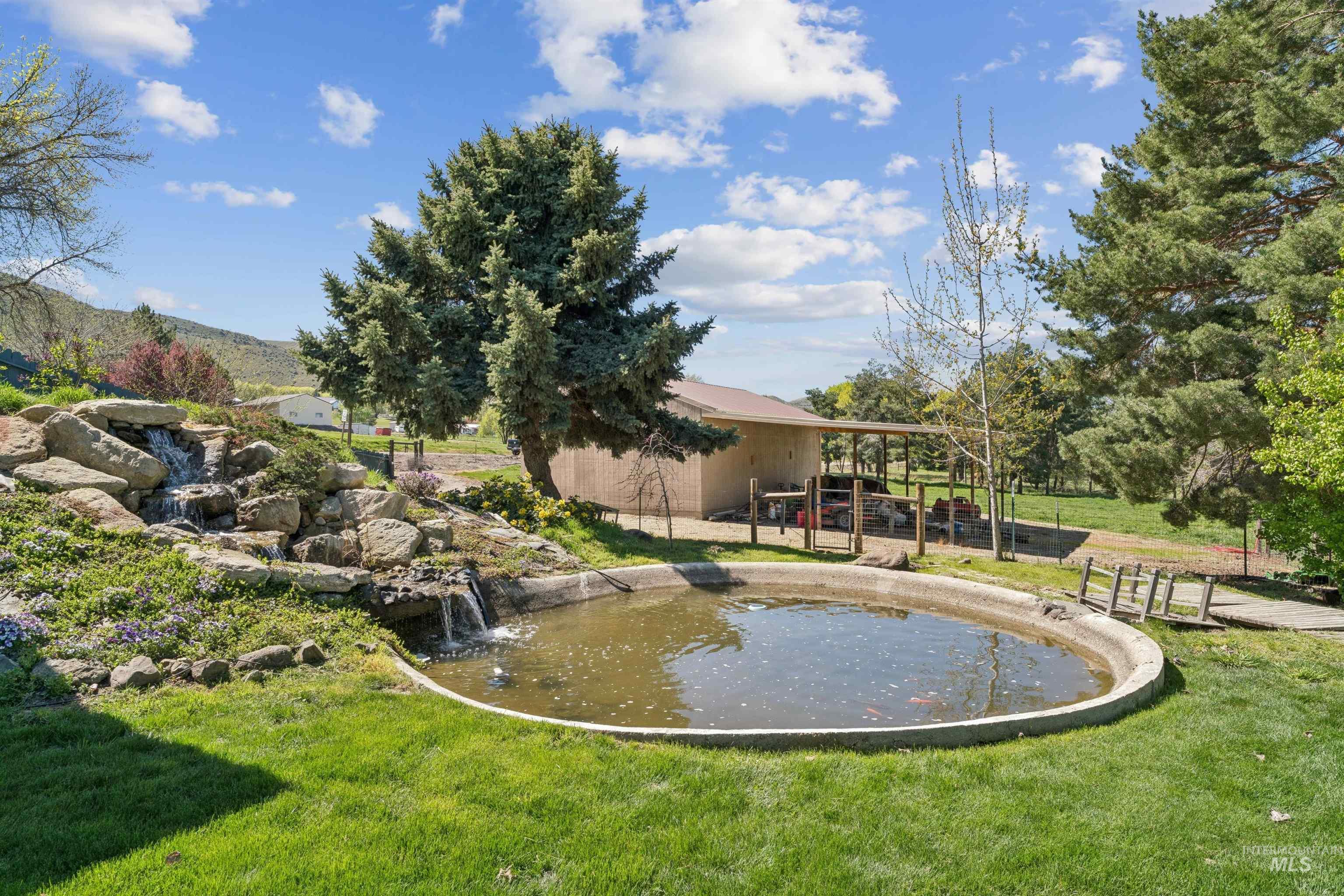 1050 West South Slope Road Emmett, ID 83617 - Photo 38 of 49 View of pool with a small pond, patio surround, an outdoor structure, and a yard