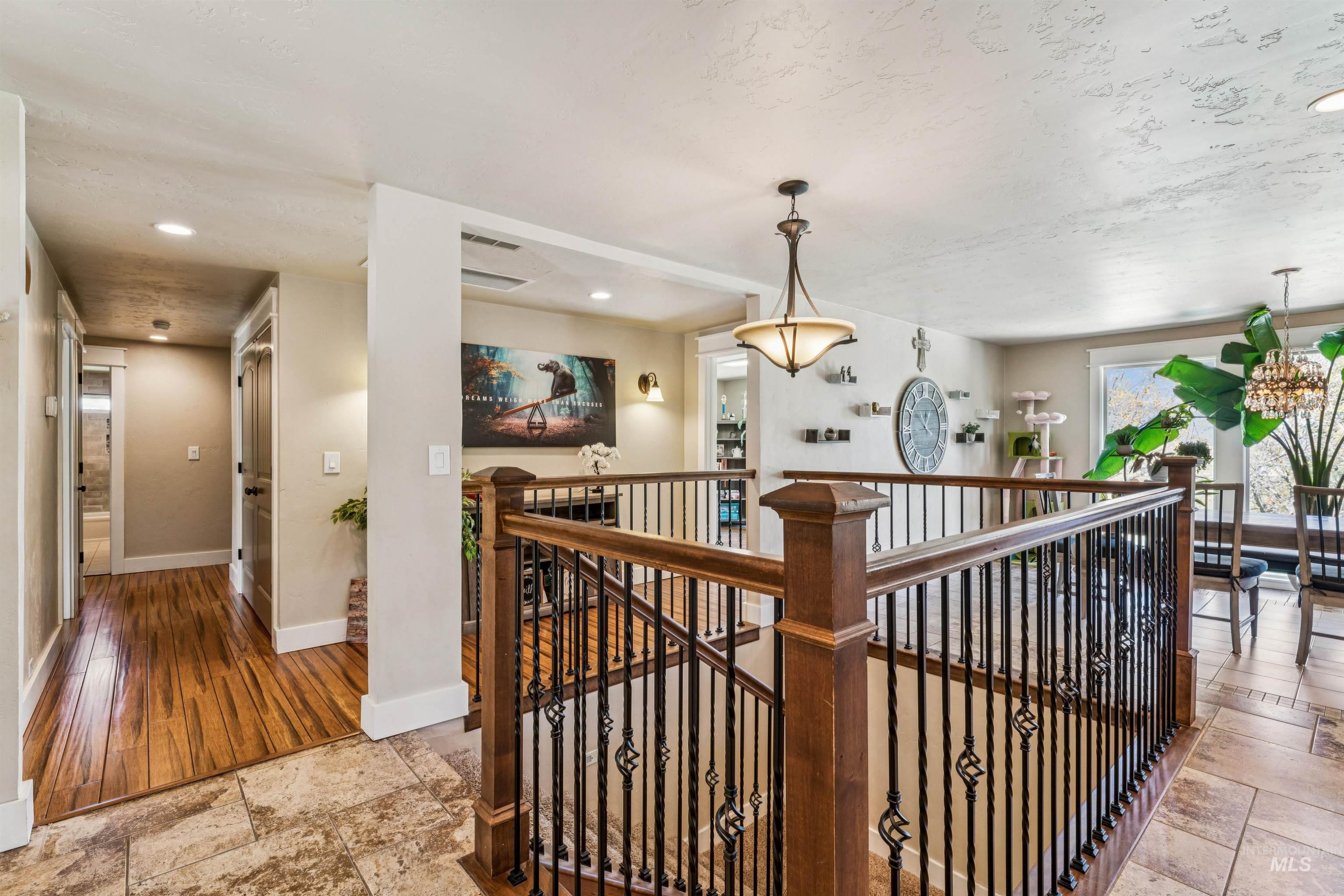 1050 West South Slope Road Emmett, ID 83617 - Photo 4 of 49 Hallway featuring stone tile flooring, recessed lighting, and an upstairs landing