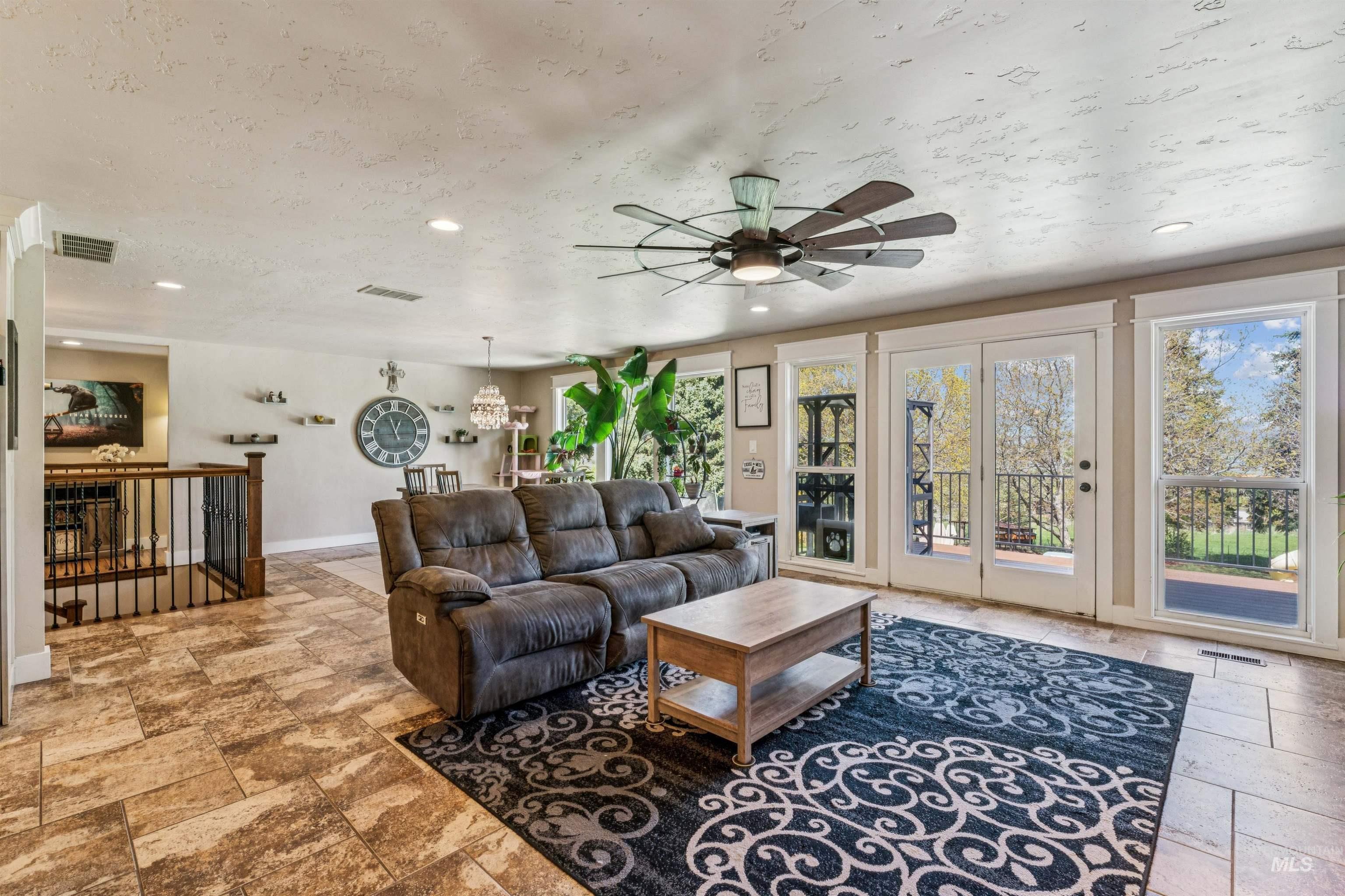 1050 West South Slope Road Emmett, ID 83617 - Photo 6 of 49 Living area featuring stone tile flooring, a textured ceiling, recessed lighting, and ceiling fan