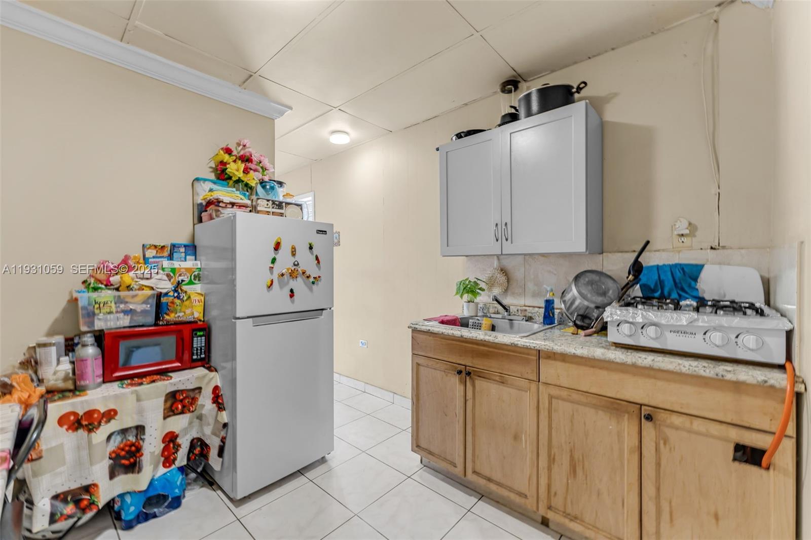 445 Northwest 8th Street Homestead, FL 33030 - Photo 8 of 32 a kitchen with stainless steel appliances a sink a refrigerator and a cabinets