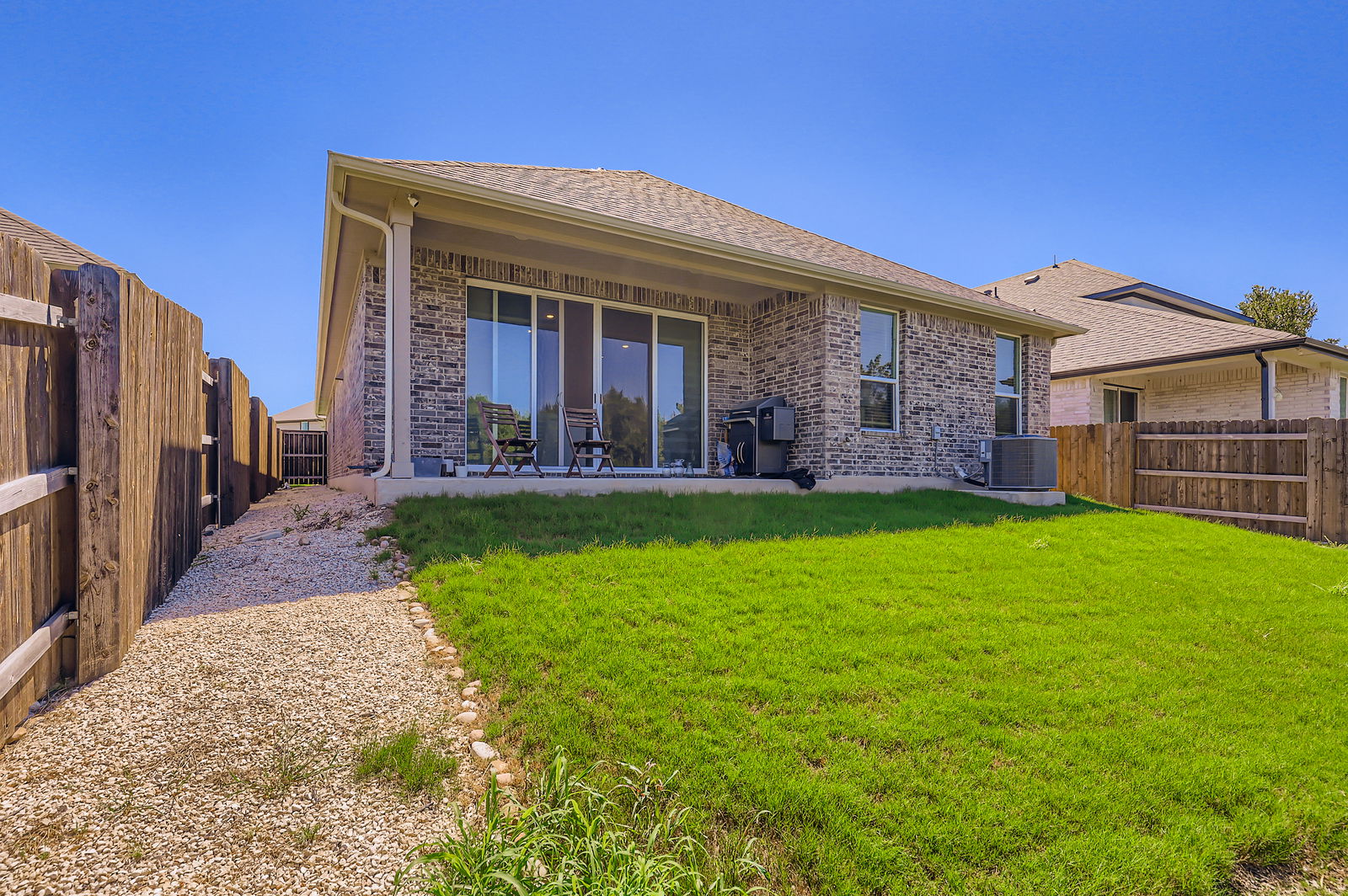 1909 Ruger Pass Leander, TX 78641 - Photo 26 of 31 Back of property with brick siding, a shingled roof, and a fenced backyard