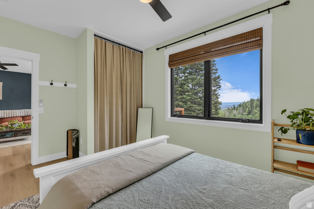 1766 West Tollgate Cyn Road Coalville, UT 84017 - Photo 34 of 59 Bedroom featuring a large window with mountain scenery, a ceiling fan, and wood-finish flooring