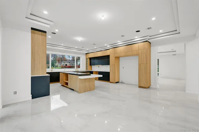 a view of kitchen with stainless steel appliances a refrigerator and a living room view