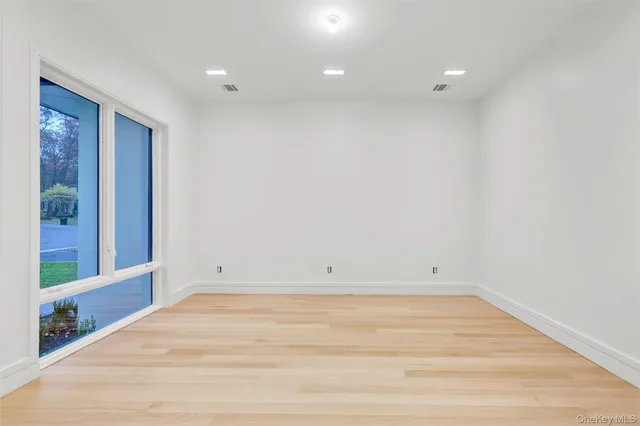 a view of a big room with wooden floor and windows