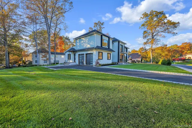 a view of a big house with a big yard and large trees