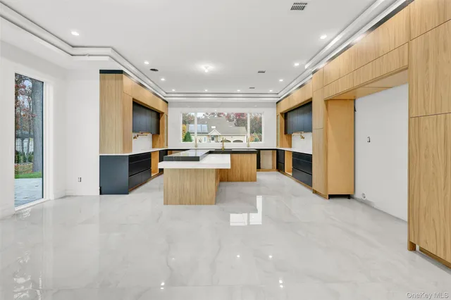 a large white kitchen with a large window and stainless steel appliances
