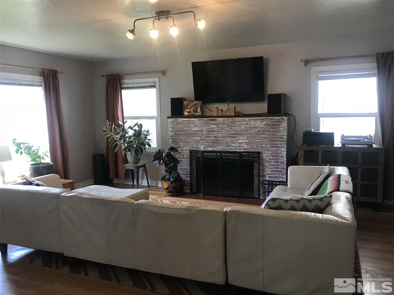 1033 University Terrace Reno, NV 89503 - Photo 3 of 22 a living room with furniture a flat screen tv and a fireplace