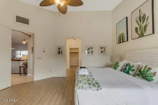 a bedroom with a bed a flat screen tv and a couch