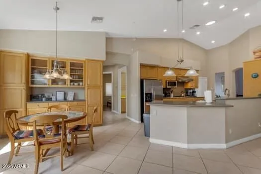 a kitchen with stainless steel appliances kitchen island granite countertop a table and chairs in it