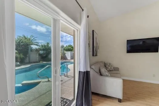 a view of a backyard with table and chairs potted plants and floor to ceiling window