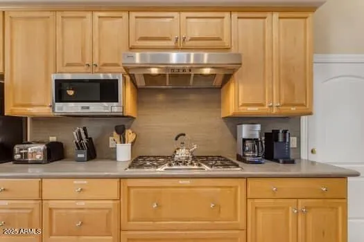 a kitchen with granite countertop white cabinets and stainless steel appliances