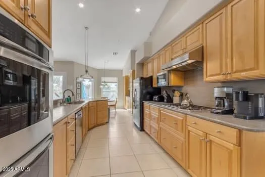 a large kitchen with stainless steel appliances granite countertop a large stove top oven a sink dishwasher and cabinets with wooden floor