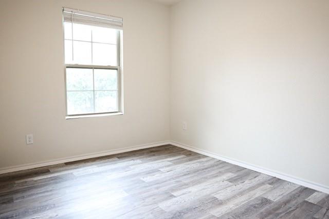 802 South 5th Street, Unit 1 Bonham, TX 75418 - Photo 22 of 25 Windowed room featuring light-toned walls, wood-finish flooring, and white baseboards