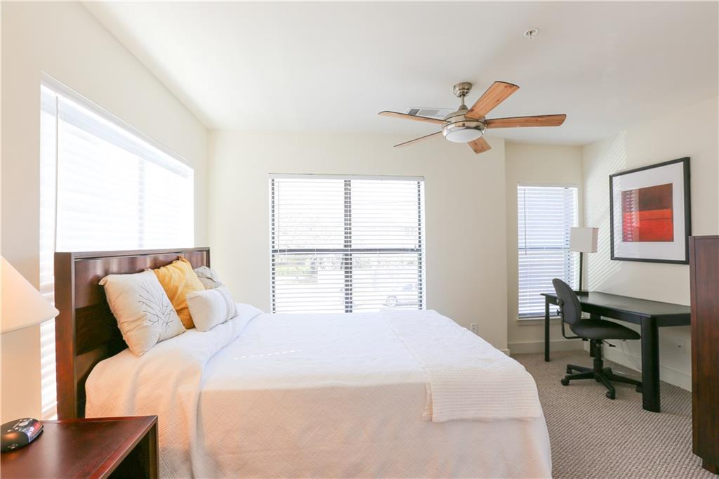 711 West 32nd Street, Unit 110 Austin, TX 78705 - Photo 13 of 24 a bedroom with a bed a desk and a chandelier