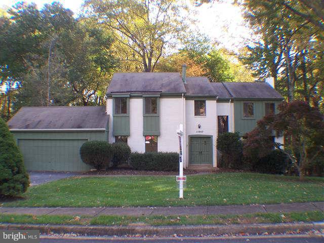 11807 Blue Spruce Road Reston, VA 20191 - Photo 1 of 30 a front view of a house with a garden and trees