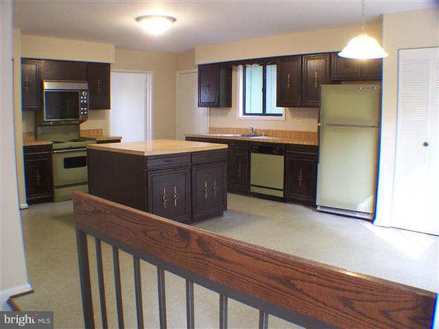 11807 Blue Spruce Road Reston, VA 20191 - Photo 8 of 30 a kitchen with stainless steel appliances kitchen island granite countertop a stove a sink and a refrigerator