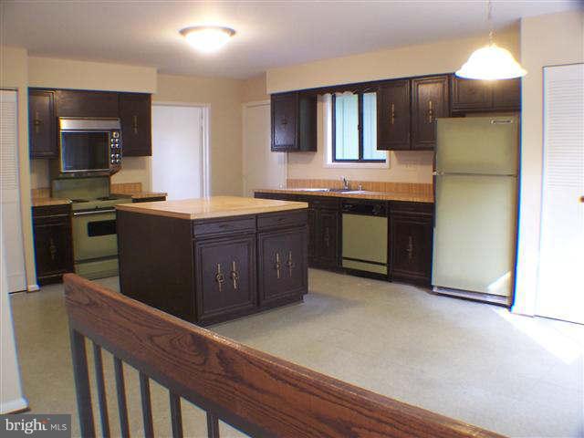 11807 Blue Spruce Road Reston, VA 20191 - Photo 9 of 30 a kitchen with stainless steel appliances granite countertop a stove a sink and a refrigerator