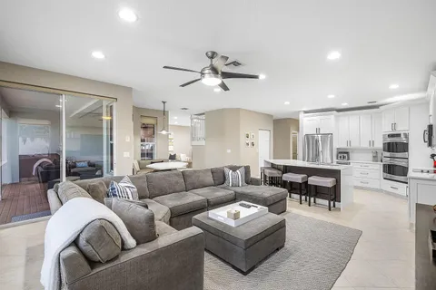 a living room with furniture kitchen view and a chandelier