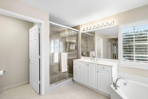 a bathroom with a granite countertop sink mirror and a bathtub
