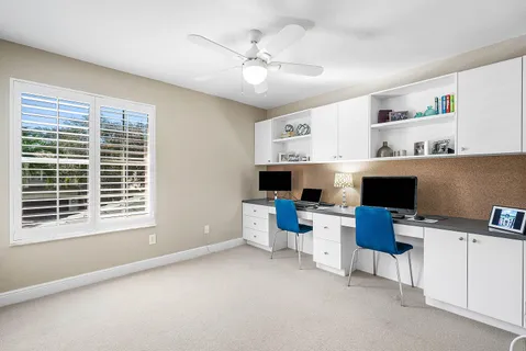 a view of a workspace with furniture and a window