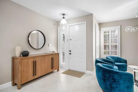 a living room with furniture a mirror and a window