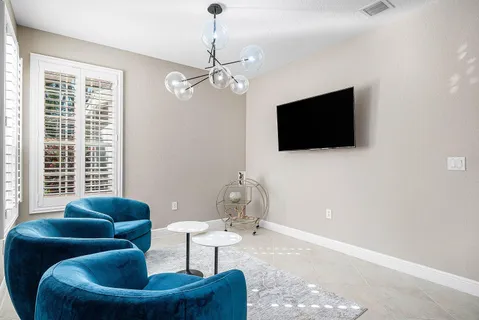a living room with furniture a flat screen tv and a window