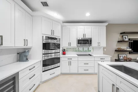 a kitchen with cabinets stainless steel appliances and a counter space