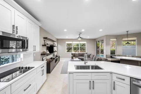 a large white kitchen with stainless steel appliances and white cabinets