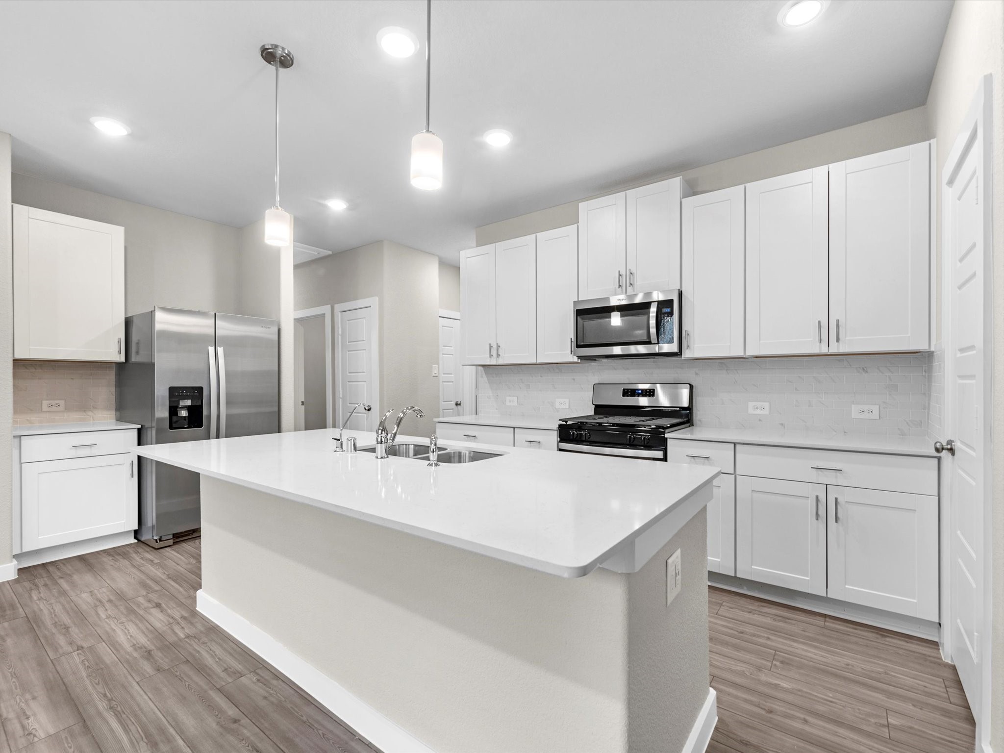 2010 West Darlington Oak Court Conroe, TX 77304 - Photo 11 of 26 a kitchen with a sink a stove a refrigerator and white cabinets