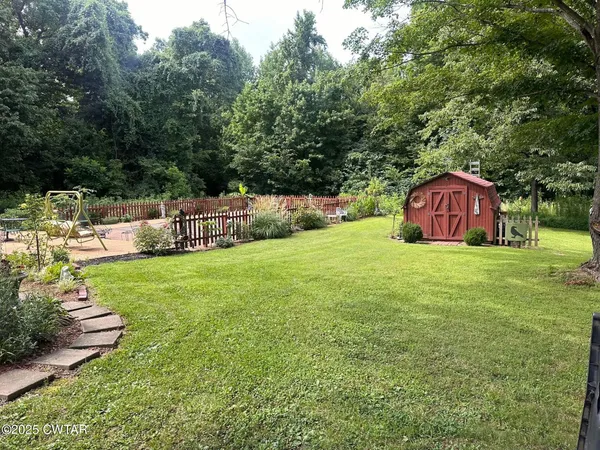 a view of a garden with large trees