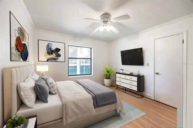 a bedroom with a large bed a window and potted plant