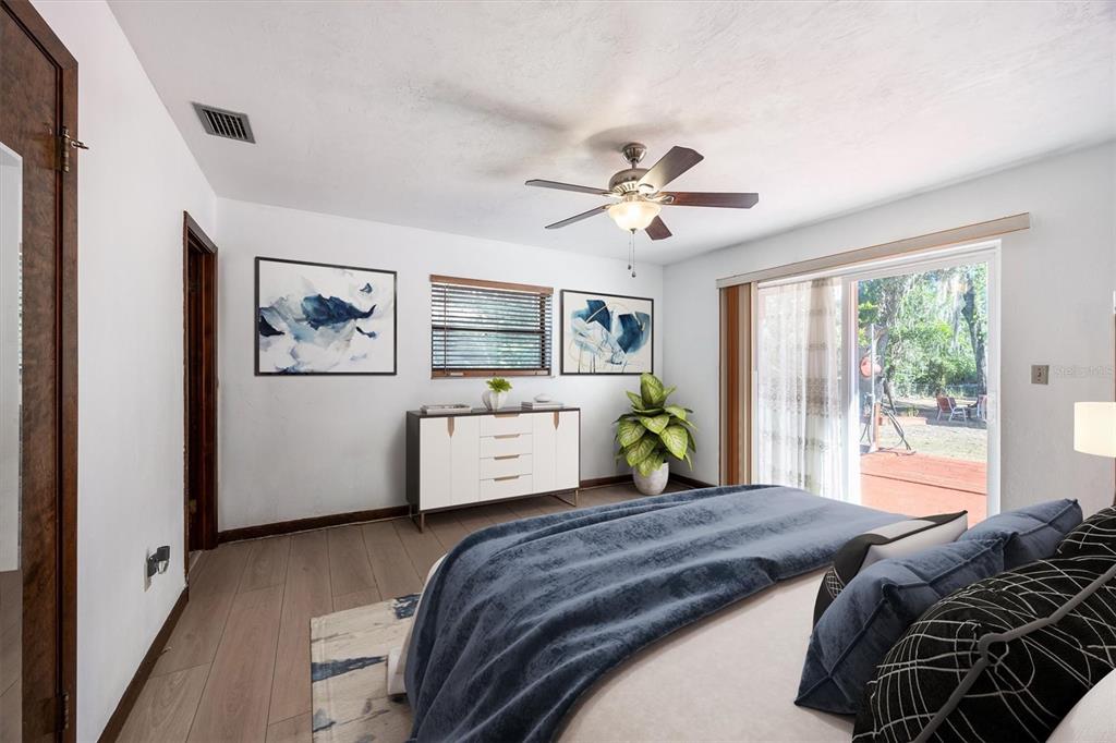 3811 Southwest 82nd Street Gainesville, FL 32608 - Photo 15 of 24 a bedroom with a large bed a window and potted plant