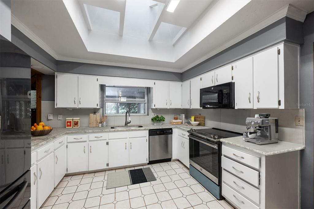3811 Southwest 82nd Street Gainesville, FL 32608 - Photo 9 of 24 a kitchen with a sink a stove cabinets and appliances